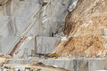 Marble quarry working machines of Carrara, Italy. Stoneworking industry. Natural resource exploitation.