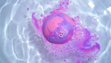 Overhead close-up of a pink and purple bath bomb dissolving and fizzing in water creating colorful foam under bright lighting