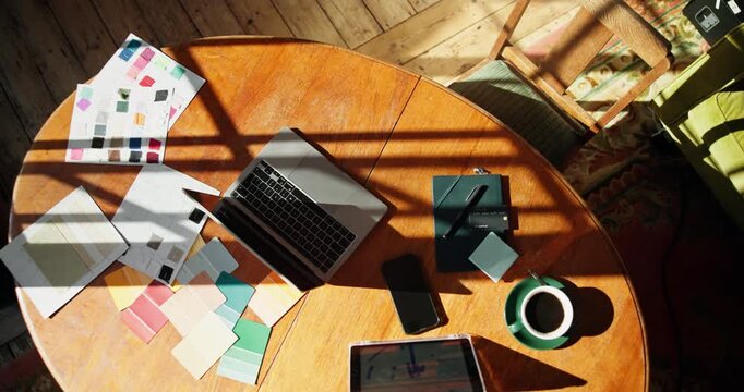 Documents, shadow and technology with desk in home for planning or remote work from above. Laptop, paperwork and tablet with stationery in empty office space for design process or freelance job