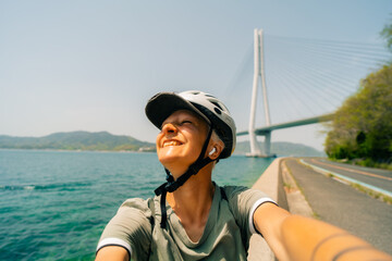 shikoku, japan - 3 august 2025 Female cyclist on Shimanami kaido cycling route