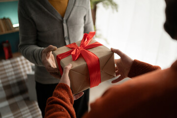 Male hands handing present box to senior man