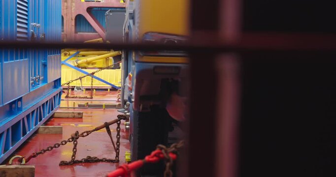 Freight vehicle stands bound on ships platform. Truck locked in steel embrace balancing on ship. Cargo bay hums with metallic tension