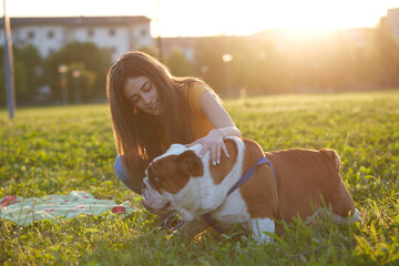 Young brunette girl play with her british bulldog