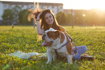 Young brunette girl play with her british bulldog