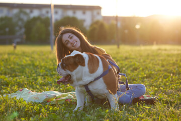 Young brunette girl play with her british bulldog