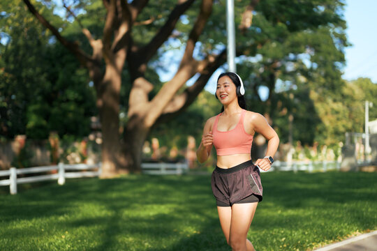 Young woman smiling while exercising and running in a park