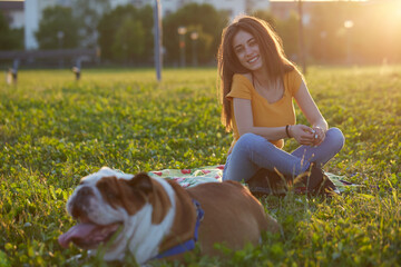 Young brunette girl play with her british bulldog