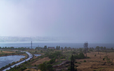 Rainstorm over lake and industrial cityscape