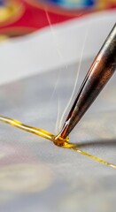 Macro close-up of a traditional canting tool applying hot liquid wax onto fabric, showing smoke and precision details during the batik making process.