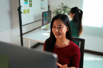 Asian woman smiling and collaborating during office meeting