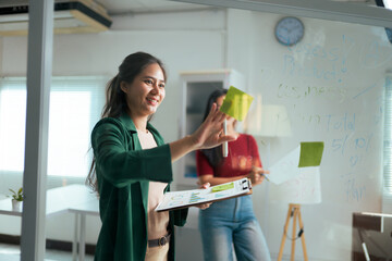 Businesswomen collaborating on planning strategy using sticky notes
