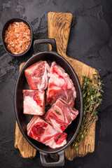 Raw chopped  lamb meat with bones, uncooked mutton ready for cooking. black background. top view