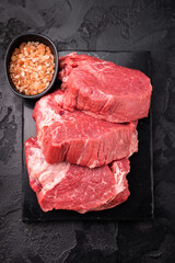 Raw beef boneless shank shin presented with herbs and spices, inspiring bold flavors and unique recipes for adventurous home cooks. black background. top view