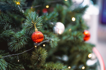 Closeup garland Christmas tree decoration,red,gold,silver ornament with bokeh background. Perfect holiday sales, winter celebration, festive seasonal promotions, marketing, shopping with copy space