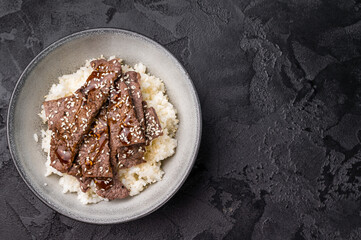 Yakiniku, wagyu marbled beef cuts and rice in a bowl. A culinary journey that captures the essence of Japanese grilling traditions. black background. top view
