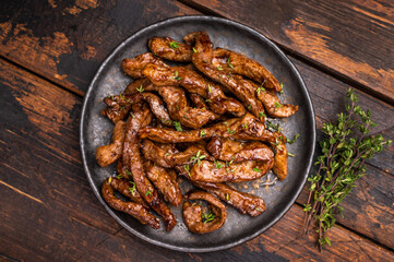 Traditional Asian beef teriyaki with herbs on a plate. wooden background. top view