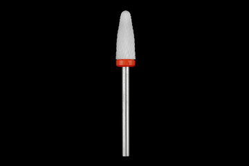 Ceramic cutter for grinding and polishing in manicure and pedicure. Drill with abrasive grain isolated on black background.
