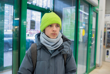 A teenage boy in winter clothes walked into a store.