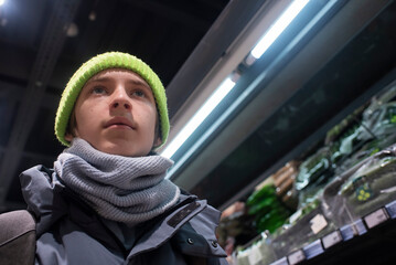 Portrait of a teenage boy in winter clothes at a grocery store