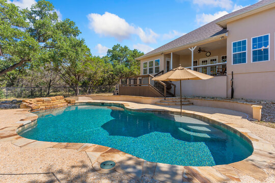 A large house with a sizable swimming pool in front of it 