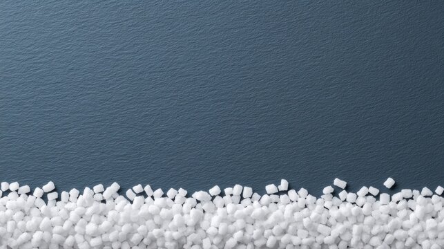 A close-up view of white sugar cubes arranged along the bottom of a textured dark surface, creating a stark contrast. - Powered by Adobe