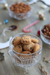Various Christmas decorations, cookies, chocolate and nuts on wooden background. Selective focus.