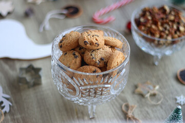 Various Christmas decorations, cookies, chocolate and nuts on wooden background. Selective focus.