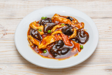 Poulet aux champignons noirs sur assiette blanche. Cuisine chinoise. Traiteur chinois.