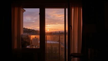 Framing balcony doorway casting warm sunset light into apartment room, showing glass railing, vase