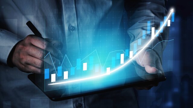 A business professional uses a digital tablet to analyze financial data with a graphical representation of growth. The upward trend reflects strategy and success in business. Copula