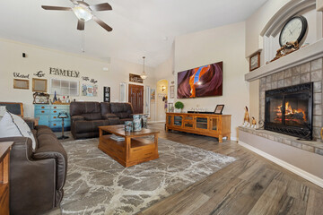 A cozy living room featuring a fireplace alongside a ceiling fan