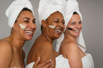 Happy multiracial women having fun together during beauty treatment skincare - Elderly people, happiness and anti aging concept