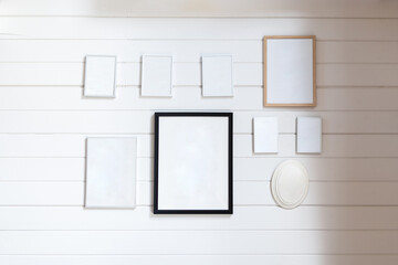 White wall with multiple empty picture frames arranged in geometric pattern