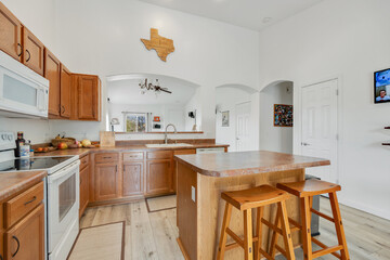 A kitchen with wood cabinets, a white stove, and granite tops
