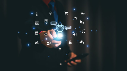 Businessman holding remote control to manage smart home automation system with futuristic AI chatbot assistant and glowing internet of things digital technology network interface.