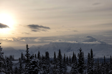 Bright sun over snowy mountains in Alaska