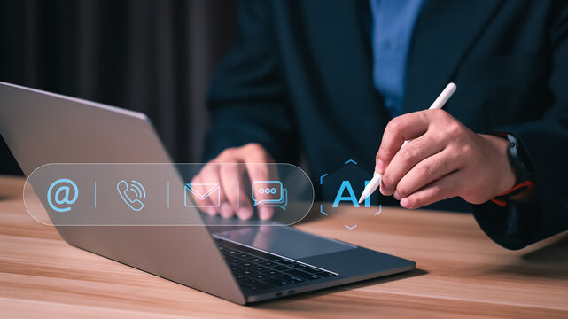 Businessman using laptop with virtual communication icons and AI chatbot. Concept of automated customer support service, digital contact center technology and smart help desk connection.