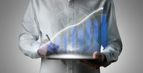 A business professional analyzes data trends using a digital tablet, showcasing a growth graph in a modern office, symbolizing success and innovation. Impute