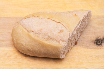 Freshly baked bread slice on a wooden cutting board, ready to eat