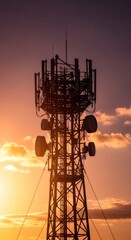 Silhouette of a telecommunication tower with antennas and repeaters at sunset. Communication infrastructure for 5G network, cellular technology, and internet.