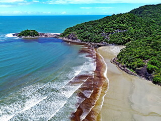 
Aerial drone view of the Bertioga coastline, Brazil. Waves with white foam reaching the beach. Meeting of dark rainwater and seawater.