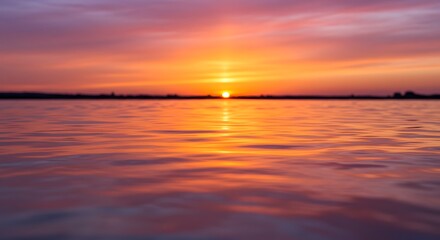 Obraz premium The way water reflects the colors of the sky at sunset.
