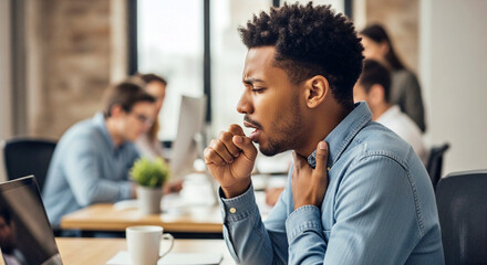 Young man coughing at his office desk, holding his throat. Concept of workplace sickness, infection spread, and poor health