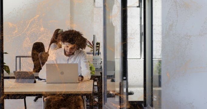Man typing on laptop, camera pulling back revealing flame overlay fading, showing business space