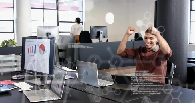 Male office worker coding laptop, cheering after success while hex code overlays tech charts
