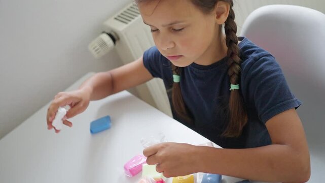child play display, child with braided hair assessed colorful squishy toys during daylight, youthful girl with braided hair carefully demonstrating tactile squishy toys under gentle sunlight