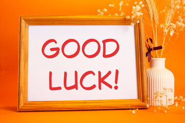 Good luck symbol. Concept words Good luck on beautiful wooden picture frame. Beautiful orange...