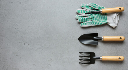 Gardening tools flat lay gloves trowel rake arrangement gray background