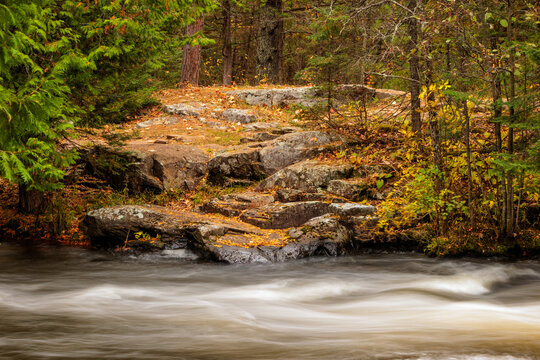 Boulders align the shoreline of the Ontonagon River just above Bond Falls within  Bond Falls Scenic Site, near Paulding, Michigan in late October