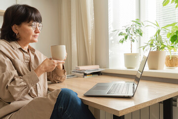 Mature woman working remotely during video call at home
